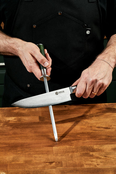A person sharpening a large HexClad kitchen knife.