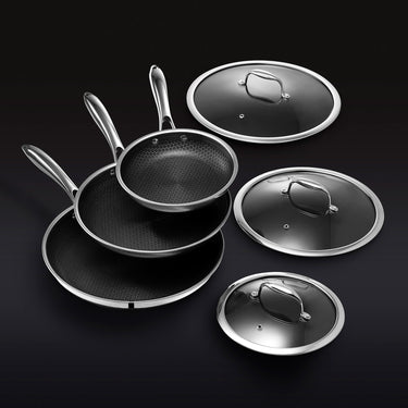 Three frying pans with lids on a black background.