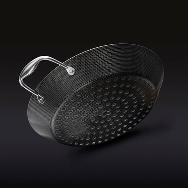 The underside of the HexClad 12&quot Hybrid BBQ Grill Pan on a black background